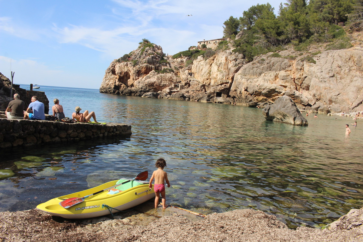 A child with a kayak at Cala Deia, Mallorca