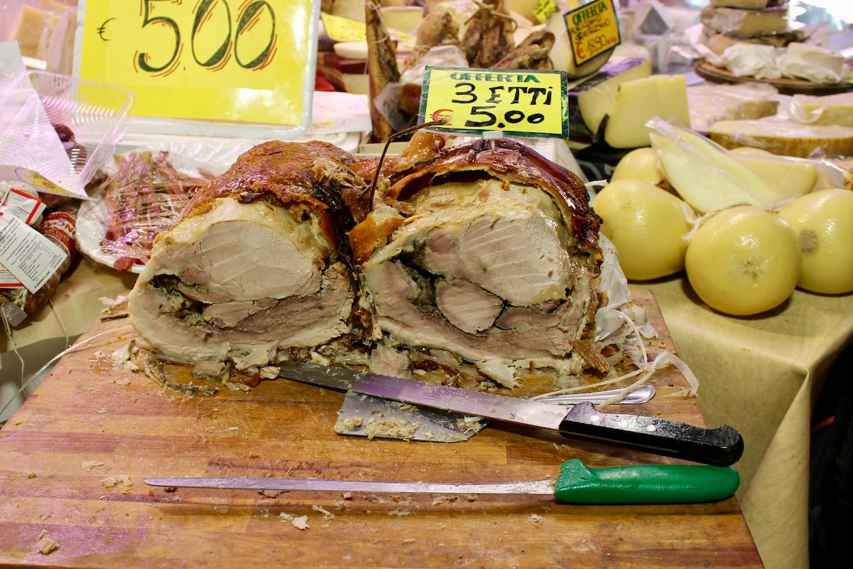 The porchetta cut in half to show the crispy skin on the outside and moist meat on the inside
