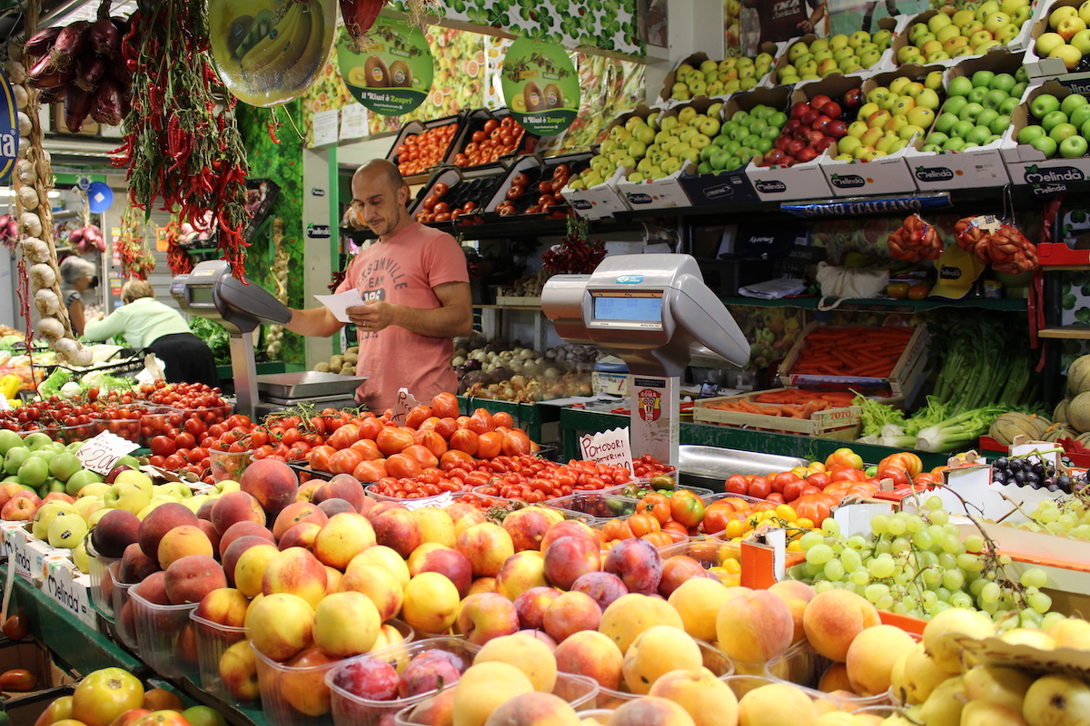 A fruit and vegetable stand at Trionfale Market in Rome, highlighting the many varieties of tomatoes