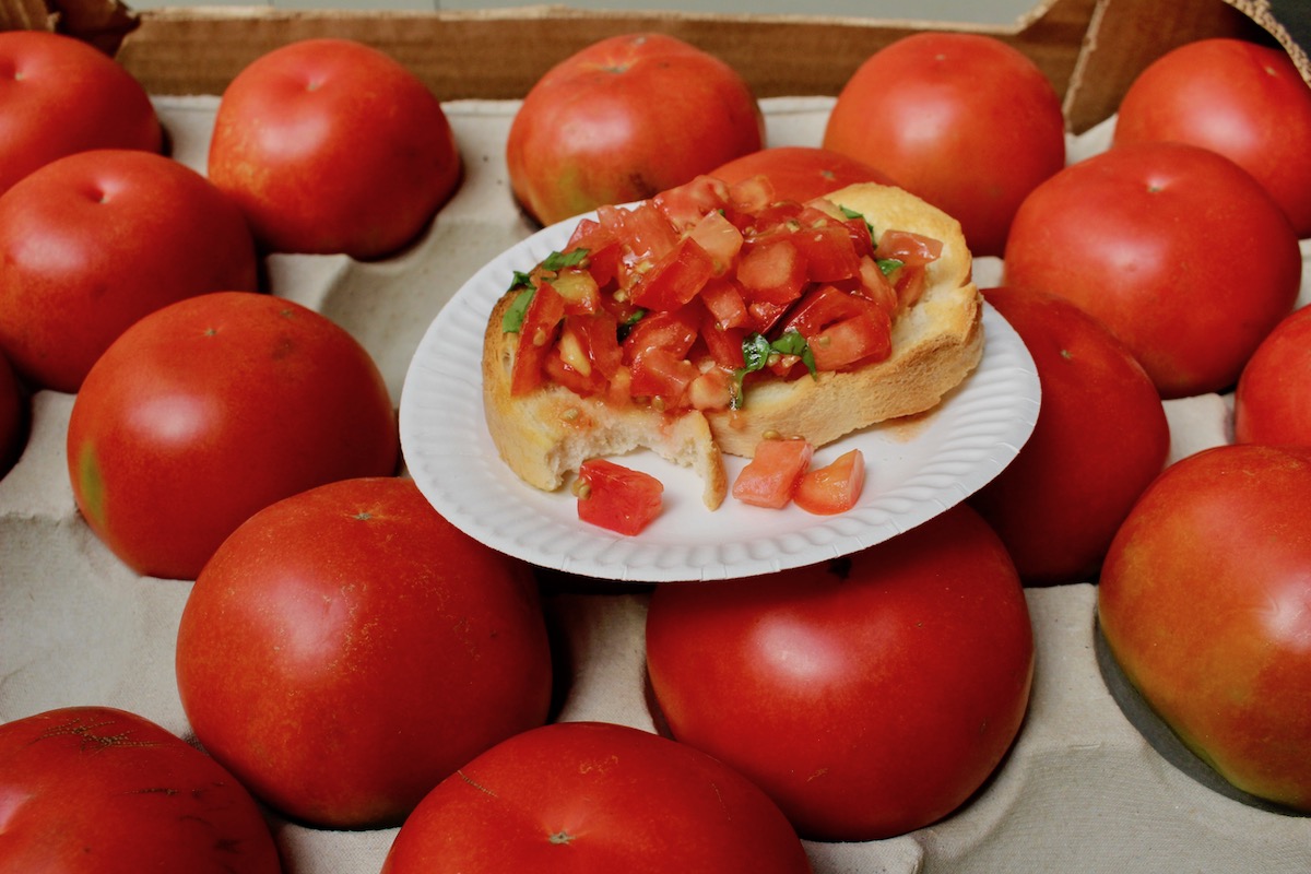 A freshly prepared tomato and basil bruschetta behind the fruit and vegetable stand at Trionfale market
