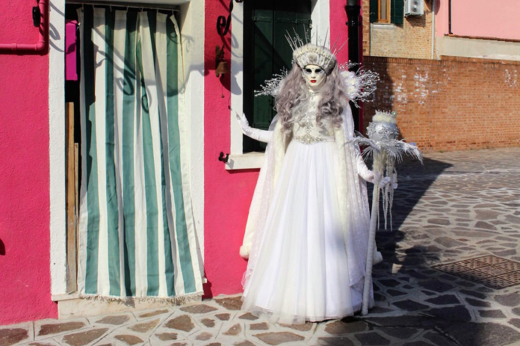 A winter princess poses outside the houses in Burano during Carnival
