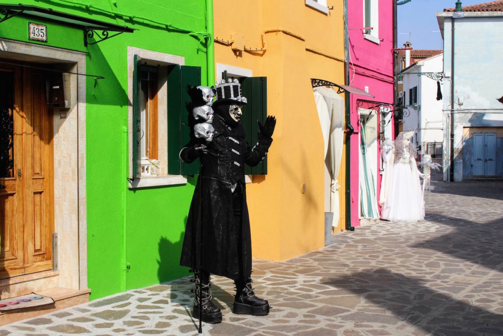 A man with skulls poses in his traditional Carnival costume in Burano, Italy