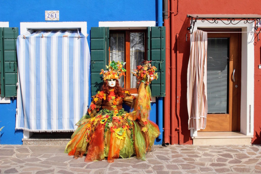 A colorful flower woman posing in Burano, Italy