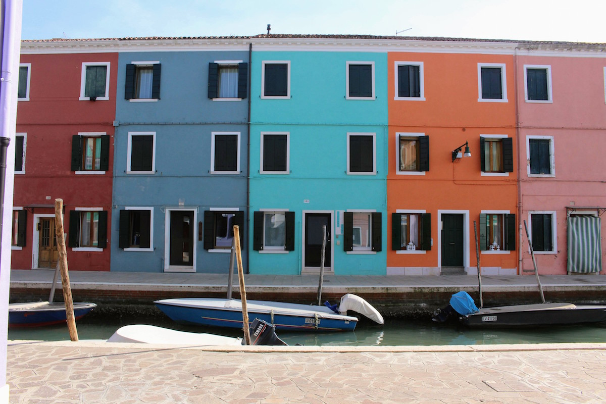 A view of a quiet street with houses and boats in Burano, Venice during Carnival