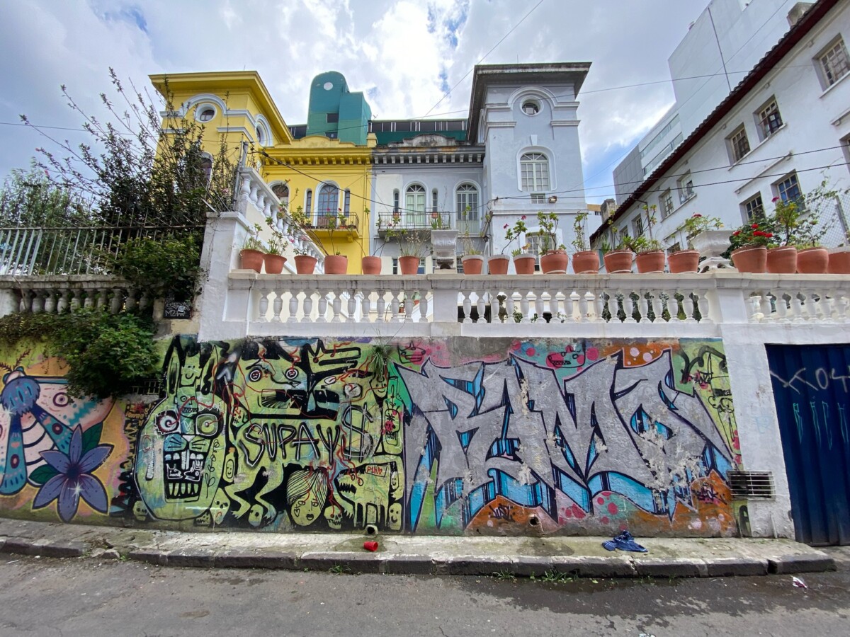 A street with graffiti and a house behind it in Quito