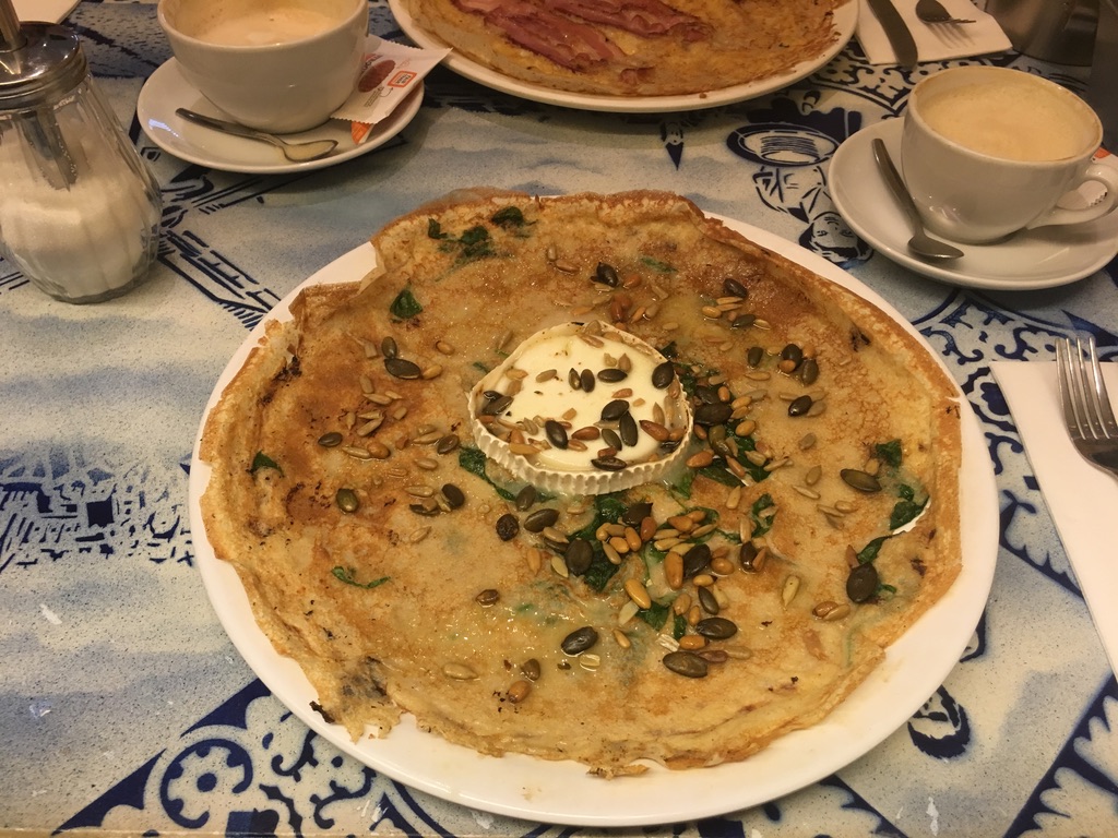 A Dutch pancake with goat cheese, spinach and seeds