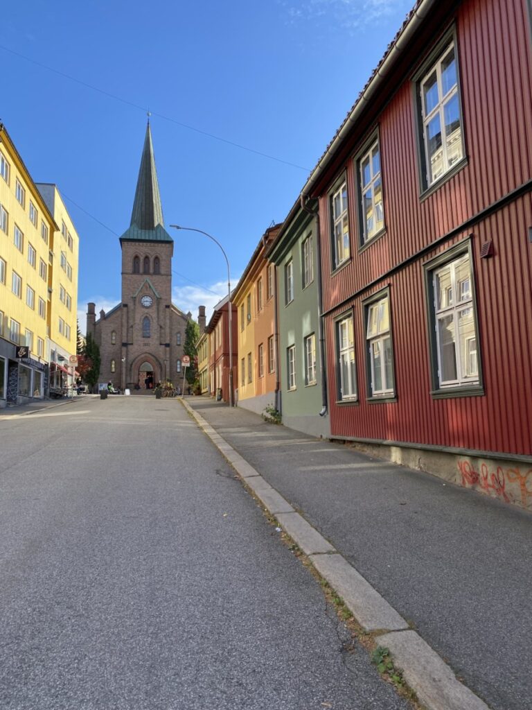 A view from the street with the church in the distance and colorful houses, Kampen, Oslo