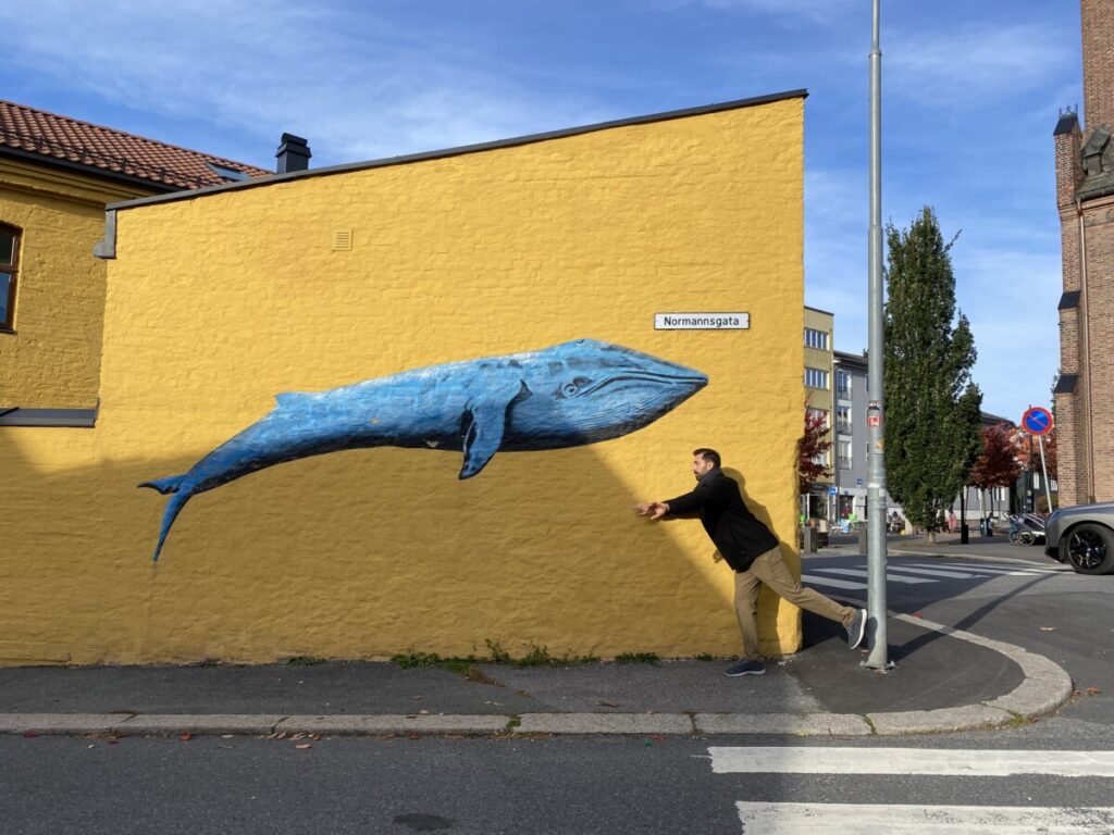 A mural of a whale on a yellow wall in Kampen, Oslo