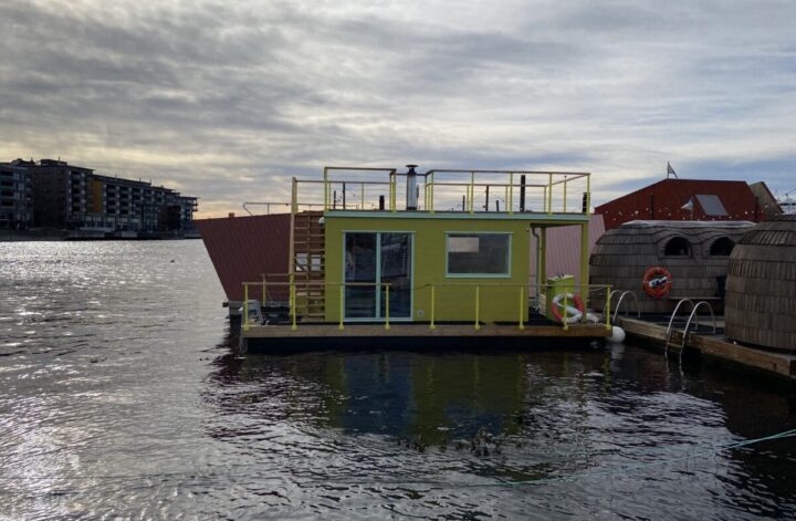 A yellow sauna floating over the fjord in Oslo