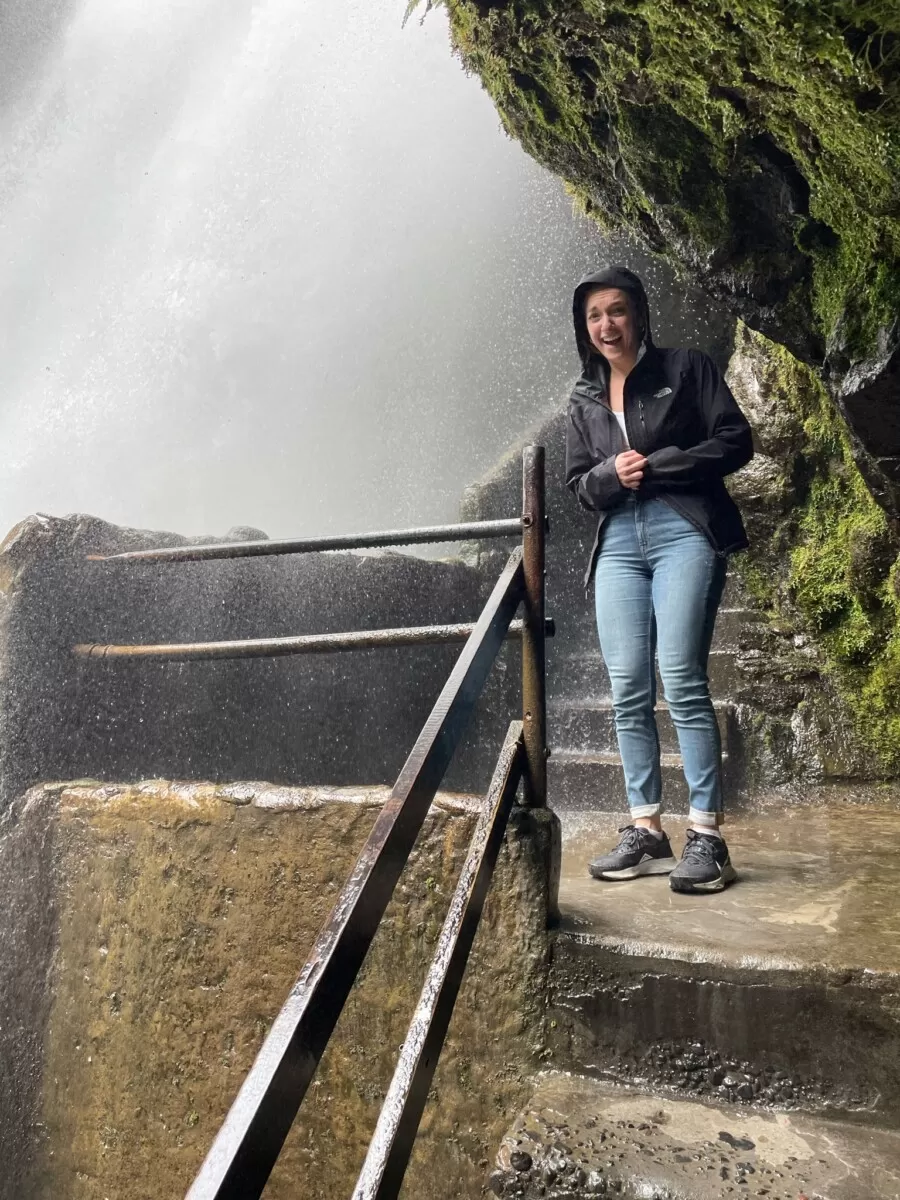Walking under the running water behind the waterfall at Pailon del Diablo waterfall park